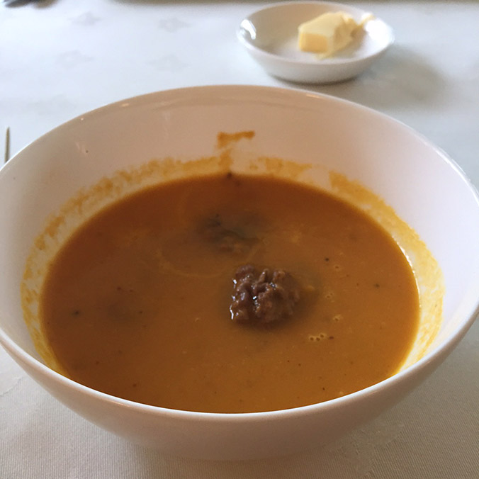 Carrot and cumin soup in white bowl